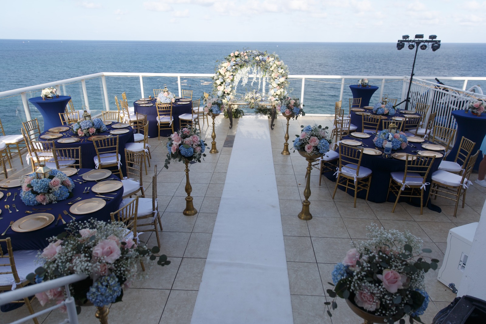 White flowers, a mirrored aisle and the ocean beyond—a setting made for a beautiful beginning.