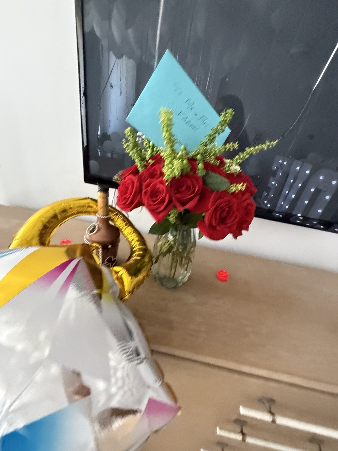 Red roses and a handwritten message add a heartfelt finishing touch to a room surprise.